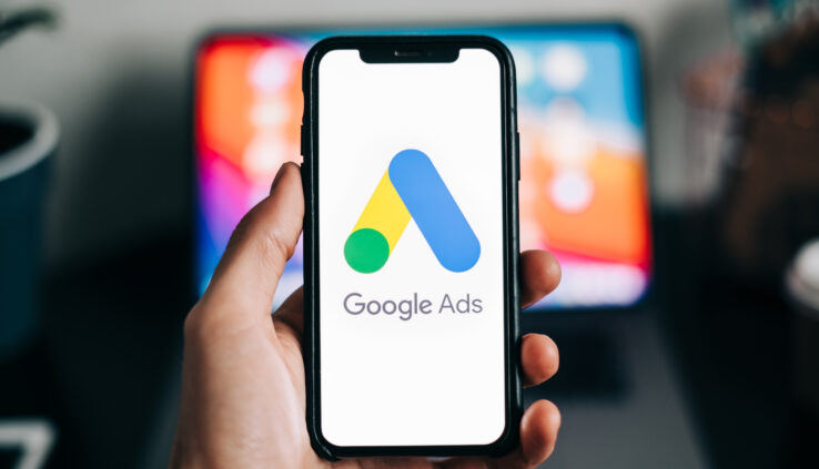 Google Ads logo on smartphone screen in hand.