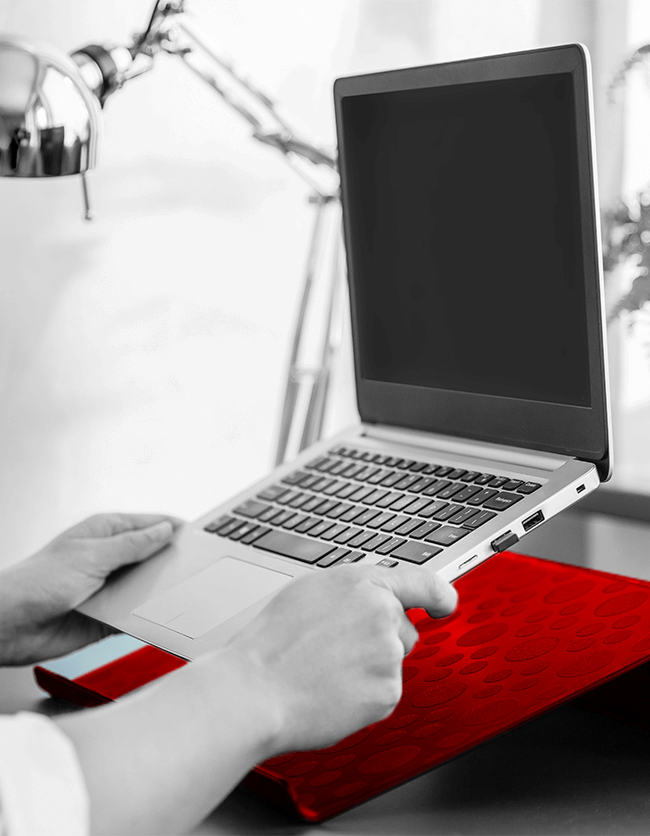 Man placing laptop on red laptop stand