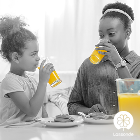 Mother and daughter drinking orange juice in the morning